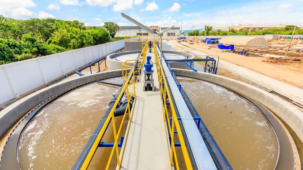 Vista aérea de tanques de sedimentación y pasarelas de control en una planta que emplea diversas soluciones para el tratamiento de aguas residuales y gestión de bombeo.
