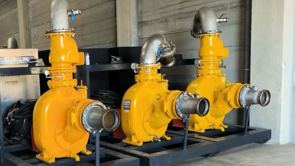 Yellow industrial rental pumps for temporary pumping, installed on a skid in a technical facility.
